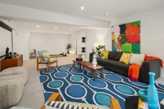 This huge lower-level rec/family room is so fun and flexible!  A wood-burning fireplace is just out of frame to the left, and a door to the lower patio and fenced backyard is just behind us.  A doorway on the far wall leads to a HUGE storage area.  The space in between offers many possibilities...