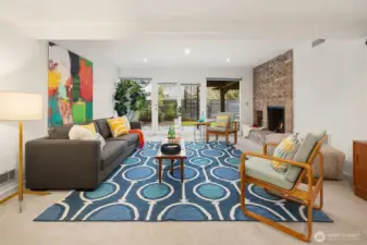 The wood-burning fireplace delivers visual and actual warmth to this wonderful room.  Both fireplaces are plumbed for gas, allowing for easy wood-starting or conversion to a gas fireplace.  Large windows let in light, and a glass door opens to the lower patio and fenced yard...