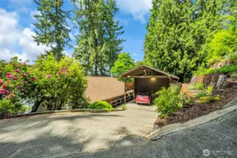 Oversized carport with mature landscaping, sprinkler system with terraced gardens