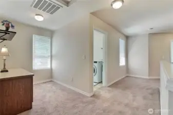 The upstairs hallway is large, wide, and bright, creating an open and welcoming feel as you move through the home. It provides easy access to the laundry room, making chores more convenient.