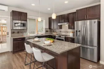 Door off kitchen to covered back patio, fenced yard, and parking behind.