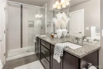 Ensuite primary bedroom's three-quarter bath with dual vanity and designer shower.
