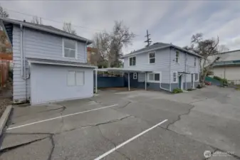 Parking area. 2 car carport and 3 open spaces. To lower left, is common laundry room with storage. Above is bedroom to Unit #6. To the right is Unit #1 on top and unit #4 on bottom.