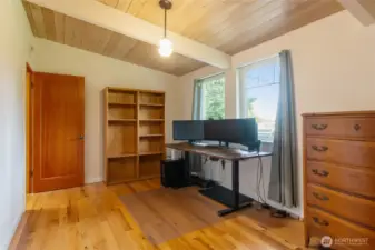 Currently used as a private office, this room showcases the beautiful hardwood floors and elegant fir doors that add warmth and character throughout the home - perfect for a focused work or a cozy guest space.