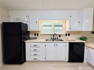Other side of the kitchen with new refrigerator, new sink and faucet, and new dishwasher.
