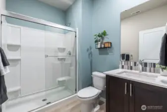 Main level bathroom with walk-in shower. Photos are representational. Actual colors and finishes will vary. See site agent for details.