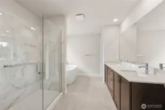 Spacious primary bath with titled walk-in shower, double vanity sink, walk-in closet. Actual home is under construction and materials, colors, and finishes will vary. See site agent for details.