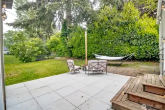 Tall hedges and mature trees create a peaceful, secluded vibe — perfect for quiet mornings with coffee or cozy nights by the firepit.