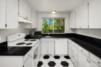 Kitchen recently updated with granite counters and looks out to the peaceful backyard.