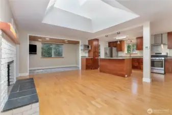 Kitchen, one of the gathering areas with a fireplace, a small dining area or reading nook, game area off of the kitchen and Island. Note the big skylight over the fireplace area.