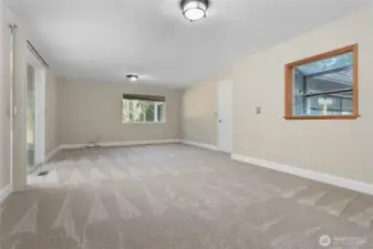 Looking to the main family room from the kitchen. Garage door on the R and the sunroom on the L.