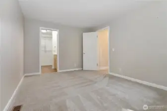 Primary bedroom looking towards the closet and bathroom on the L and the hall on the R.
