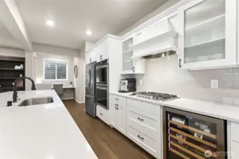 The light-filled kitchen shines as the heart of the home, where expansive windows and an open layout create an airy, welcoming atmosphere. A work station/nook just off of the kitchen is a wonderful flex space for a variety of uses.