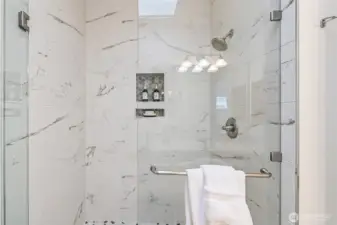 This oversized, updated primary shower features elegant designer touches for a spa-like experience.