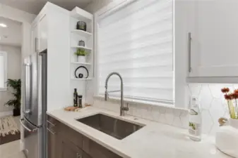 Undercabinet lights, large single bowl sink, and huge kitchen window are highlights of this kitchen.