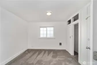 This light and bright bedroom offers fresh carpet, a large window for natural light, and charming built-in closets with overhead cubbies for extra storage. Whether you're furnishing your first home or creating a stylish rental, this room checks all the boxes for comfort and functionality.