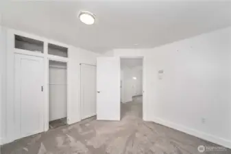 This angle highlights the built-in closet system with overhead storage—perfect for staying organized. The open doorway connects seamlessly to the main living area, giving the room a comfortable and functional layout for everyday living.