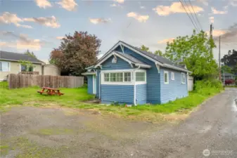 Fresh exterior paint gives this 1-bedroom home standout charm, complemented by a low-maintenance yard and gravel alley access. The picnic table and open lawn space add a touch of lifestyle potential—great for relaxing or casual outdoor dining.