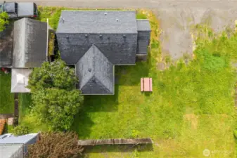 This overhead shot highlights the full layout of the home and yard. Notice the spacious green lawn, alley access, and dedicated area for outdoor seating or entertaining. A great perspective on lot size and layout in relation to neighboring properties.