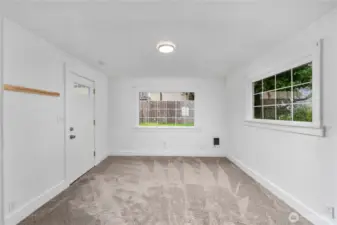 This inviting living space features fresh carpet, crisp white walls, and large windows that let in tons of natural light.