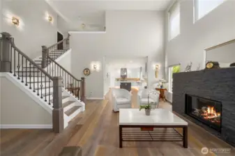Step inside, and the world falls away. Wide-plank luxury engineered hardwood floors stretch beneath soaring vaulted ceilings, their warm hues accented by intricate crown molding and gracefully rounded corners throughout. The a bespoke limestone fireplace that radiates warmth and grandeur!