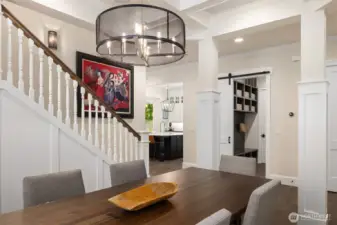 Serving up style: this chic dining room delivers standout lighting, architectural charm, and a sneak peek into the ultra-organized mudroom—because even your coats and shoes deserve a designer moment.