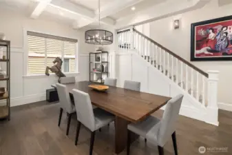 Dinner with a side of clever design—this elegant dining room stuns with coffered ceilings, statement lighting, and a hidden surprise: a discreet under-stair storage space that’s perfect for tucking away anything from table linens to your secret snack stash.