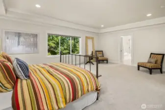 A wall of windows, a treetop view, and a whole lot of breathing room—this primary suite is giving luxury hotel vibes