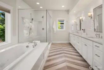 Chevron floors, dual vanities, and a soaking tub with a garden view—this spa-like bath checks every box on your “treat yourself” list.