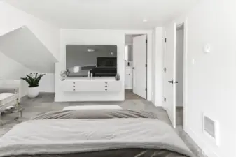 Virtually staged. Primary bedroom with peak into en-suite bathroom and closet.