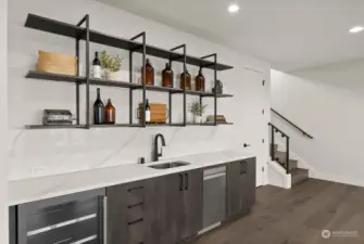 Elevate your entertaining with this sleek, modern wet bar, complete with a beverage center and dishwasher, designed to meet all your hosting needs in style