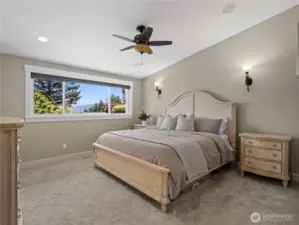 Bathed in natural light, the room boasts a generous window offering scenic outdoor views, perfectly enhancing the calm, neutral tones of the walls and carpeting