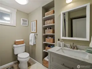 This thoughtfully designed bathroom maximizes space with smart storage solutions and a fresh, neutral aesthetic.