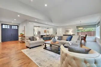 The Main Living Area... view of the entry, office and primary suite to the left, kitchen in the distance, then the hallway to the garage, main-level powder room, and staircase to the second story