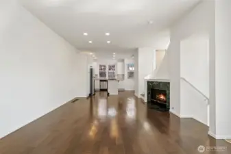 Expansive main area with canned lights, wood floors, fresh paint, gas fireplace - plus kitchen and laundry all accessible for easy living.