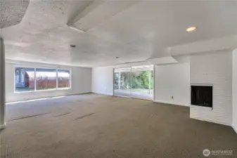 Check out this HUGE family/livingroom area on the lower level of the home.  The HUGE slider leads to the patio and to the .91 acre park-like property. This level offers this HUGE family/livingroom with fireplace, kitchenette, two flex rooms, gorgeous tiled 3/4 bath with the slider to the backyard and a door offering a seperate access not using the upper level