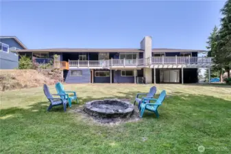 Looking from the back yard over the firepit to the back of the home