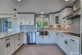 Gorgeous tiled floor and backsplash, farmhouse sink in the updated, modern kitchen with lots of beautiful cabinetry and stunning marble counter tops along with stainless appliances.  Nothing to do here but start cooking.