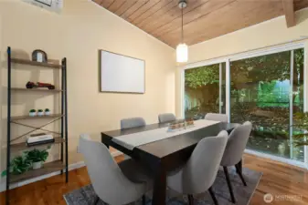 Large dining room with slider to back deck and vaulted wood ceiling