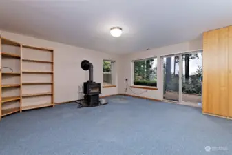 Downstairs rec room with a wood stove and TONS of storage cabinets. The one to the right in this photo has many small pull-out drawers in it to organize all of your hobby supplies.