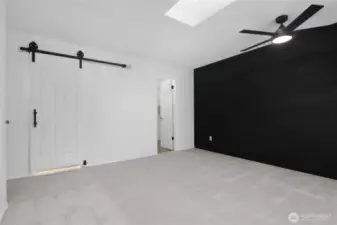 Primary bedroom showing barn style door to bathroom and walk-in closet to the right.
