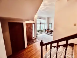 Foyer entrance with hardwood flooring. Short stairs leads to dining, kitchen and family room with new wood floorings. Large hallway leads to half bath, closet for storage with garage door entrance towards the left.