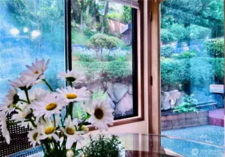 Breakfast area looking into backyard with white flowers straight from the garden in front of you.