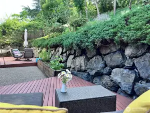 Two built patio decks on ground level. Full retaining wall all around the back of the property. Slops to large hill with built in steps and path access to your private trail.