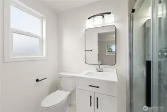 Newly renovated master bathroom featuring a new tile shower, updated vanity, and modern fixtures