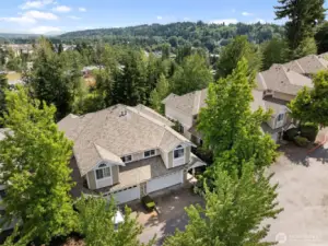 Aerial view captures the home’s setting, surrounding greenery, and peaceful community feel.