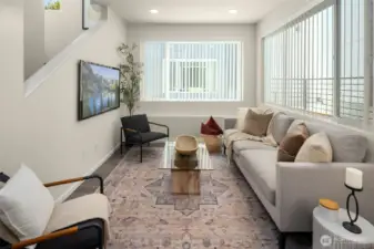 Sun-soaked living room with tall ceilings and oversized windows — every day feels a little more elevated.