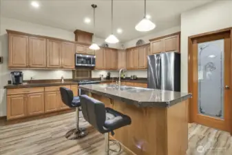 kitchen that boasts New Stainless Steel Appliances, walk in pantry, abundant cabinet storage, tons of counter space, and Large Island with room for bar stools