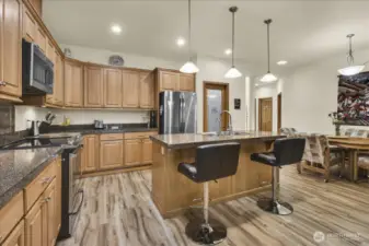 kitchen that boasts New Stainless Steel Appliances, walk in pantry, abundant cabinet storage, tons of counter space, and Large Island with room for bar stools