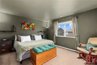 Spacious primary bedroom with natural light, neutral tones, and room for large furniture.